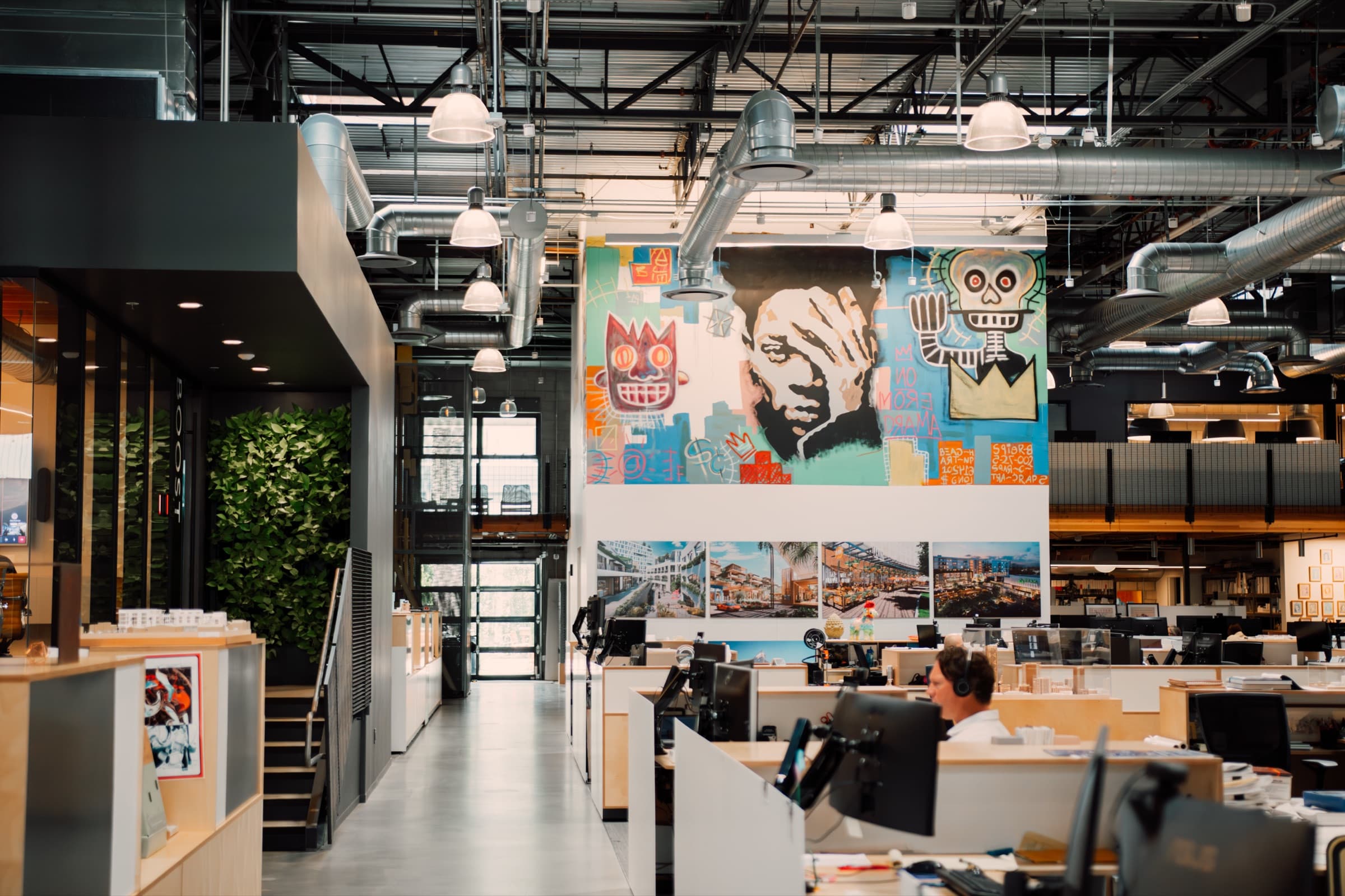 An open office with a mural above the desks